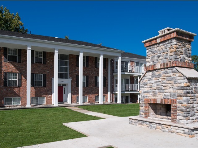 Relax by the outdoor stone fireplace in the beautiful courtyard at University Hills Apartments near the University of Toledo. - University Hills