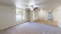 Located in Beaverton, Oregon, this single-floor, 4-bedroom, 2-bathroom home offers a well-organized and functional layout designed for comfortable living. The entrance leads into a hallway that connects the main living spaces. The combined living and dining area is bright and open, featuring plush carpeting, a ceiling fan with integrated lighting, and large windows that fill the space with natural light and frame views of mature trees and a nearby playground. A sliding door provides access to a covered wooden balcony, extending the living space outdoors.

The kitchen is efficiently designed in an L-shape configuration, featuring warm wood cabinetry, ample counter space, a double-basin sink, and white appliances including a dishwasher, range, and refrigerator. Stone-look tile flooring runs throughout the kitchen, bathrooms, and closet areas, while soft carpeting is found in the living areas and bedrooms.

Each of the four bedrooms offers carpeted floors and windows providing natural light and outdoor views. The primary bedroom includes generous closet space with wire shelving systems. Notably, the home features seven closets in total, providing exceptional storage throughout. The two bathrooms are finished with stone-look tile flooring and wood-toned vanity cabinetry with mirrors and overhead lighting. This home offers a practical and comfortable living environment in a well-established Beaverton community.