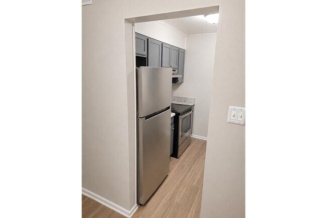 Adéntrate en la comodidad moderna de los apartamentos Richmond Hills. Esta elegante cocina cuenta con electrodomésticos de acero inoxidable y gabinetes modernos, perfectos para crear delicias culinarias. ¡Agenda una visita hoy mismo y descubre tu futuro hogar! - Richmond Hills Apartments