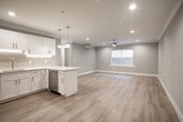 Located at 77 S Tyson Ave in Floral Park, NY, this thoughtfully renovated single-floor unit showcases a clean, modern aesthetic throughout. Light neutral walls, crisp white trim, and light-toned hardwood-style flooring create a cohesive, airy atmosphere across every room.

The open-concept kitchen and living area serves as the heart of the space. The kitchen is outfitted with white shaker cabinetry, a subway tile backsplash with under-cabinet lighting, quartz countertops, a peninsula with pendant lighting, and a full suite of stainless steel appliances. The adjoining living area is generously proportioned, featuring recessed lighting, a ceiling fan, a wall-mounted mini-split HVAC unit, and a window that brings in natural light.

Additional rooms provide flexible living arrangements, each finished with the same light flooring, neutral walls, recessed lighting, and individual mini-split units for climate control. Windows in each room allow for natural light and ventilation.

The space includes two bathrooms, both finished to a high standard. One features a soaking tub with full subway tile surround and a frameless glass panel, while the second offers a walk-in glass-enclosed shower, a white vanity with a quartz countertop, and large-format floor tiles. Together, they reflect a consistent attention to clean, contemporary design throughout the entire unit.