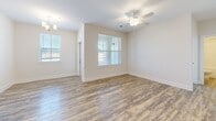 Located at 410 Redbud Ridge Dr in Knightdale, NC, this single-floor residence offers four bedrooms, two bathrooms, and a thoughtfully designed layout. The open living and dining area features warm wood-look vinyl plank flooring, a ceiling fan, and multiple windows that fill the space with natural light, creating a bright and welcoming atmosphere. The kitchen is outfitted with gray cabinetry, stainless steel appliances, and ample counter space, making it both functional and stylish. The generously sized primary bedroom stands out with its abundant square footage and access to a walk-in closet equipped with built-in wire shelving for organized storage. The remaining three bedrooms are carpeted in a neutral tone, each featuring windows with blinds that allow for natural light and privacy. Both bathrooms are finished with gray vanities, granite-style countertops, and wood-look flooring. One bathroom includes a glass-enclosed shower, while the other features a shower-tub combo. Clean lines, neutral walls, and consistent finishes throughout give the home a cohesive, move-in-ready appeal suited for comfortable everyday living.