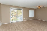 Located at 28850 Telegraph Rd in Southfield, Michigan, this single-floor unit offers a well-designed layout with comfortable living spaces throughout. The expansive living room features plush wall-to-wall carpeting, a ceiling fan, a textured ceiling, and generous natural light provided by large sliding glass doors that open to an outdoor view and an additional window dressed with vertical blinds. A pass-through partition wall connects the living area to the kitchen, maintaining an open and connected feel. The kitchen is well-appointed with rich, warm-toned wood cabinetry extending to the upper walls, granite-style countertops, hardwood-style flooring, and a full suite of stainless steel appliances including a refrigerator, electric range, dishwasher, and microwave. The bedroom offers carpeted flooring and features dual access points, including a spacious walk-in closet providing ample storage. The full bathroom is finished with a granite-topped vanity with an undermount sink, rich wood cabinetry, classic mosaic tile flooring, and a full tub and shower combination. Entry closets provide additional storage conveniently near the front door, completing this thoughtfully arranged living space.