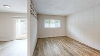 Located at 1101 Northwest 39th Avenue in Gainesville, Florida, this single-floor, one-bedroom, one-bathroom unit offers a efficient and functional layout. Throughout the space, wood-look plank flooring lends warmth and cohesion, while textured ceilings add a classic touch overhead.

A defining architectural feature of this unit is the decorative breeze-block wall, a retro mid-century design element that runs through both the living and bedroom areas. The open geometric pattern of the breeze blocks allows diffused natural light to filter through, enhancing the bright and airy atmosphere. The dining area is conveniently integrated into the main living space.

The bedroom is a comfortable, well-proportioned room with a window overlooking the outdoors, providing ample natural light and ventilation. A dedicated closet adds practical storage.

The bathroom is finished with large-format, neutral-toned tile surrounding the tub and shower combination, complemented by wood-look flooring that continues the unit's consistent aesthetic. A medicine cabinet provides additional storage.

A sliding glass door in the living area opens directly to an outdoor patio space, offering a seamless connection to the exterior and views of surrounding greenery — a welcome feature for everyday living.