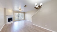 This two-story home offers a thoughtfully designed floor plan spread across two evenly sized levels. The main floor features a bright, open-concept living, dining, and kitchen area finished with light luxury vinyl plank flooring throughout. The living room is anchored by a fireplace, an elegant chandelier, a ceiling fan, and a large sliding glass door that fills the space with natural light and provides outdoor access. The kitchen is designed with white cabinetry, light countertops, a double sink, and a full suite of appliances, complemented by a pass-through breakfast bar and an adjacent pantry for added storage. A dedicated laundry room and access to the attached single-car garage complete the ground level. Upstairs, the generously sized primary bedroom is a spacious retreat featuring multiple windows, a ceiling fan, plush carpeting, and a large walk-in closet with wire shelving. Three full bathrooms serve the home, including one featuring a tiled soaking tub and shower combination. Additional closets and hallway storage provide ample organization throughout. The home's neutral color palette, consistent finishes, and practical layout make it a versatile and comfortable living space.