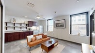 Located at 1004 N 10th St in Milwaukee, WI, this one-bedroom, one-bathroom unit offers a well-designed layout that maximizes every inch of its compact footprint. The open-concept living and kitchen area serves as the heart of the space, where a ceiling fan overhead and multiple windows allow natural light to fill the room, creating a bright and airy atmosphere. Light-toned tile flooring runs throughout, lending consistency and a clean aesthetic across all areas.

The kitchen is thoughtfully appointed with rich dark wood cabinetry, granite-look countertops, a double-basin sink, and white appliances including a range and refrigerator. Open shelving above the counters adds both storage and visual interest, while a small dining area nearby provides a convenient spot for everyday meals.

The living area offers comfortable room for seating and relaxation, with a view that connects seamlessly to the kitchen, making the space feel larger than its footprint suggests.

The bedroom is a cozy, private retreat with clean white walls and tile flooring, providing a quiet space to unwind. The bathroom features a dark wood vanity with a white countertop, a large mirror, and a walk-in shower enclosed by a glass door, completing the unit with a polished, modern finish.