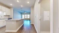 Located at 1701 Rinehart Rd in Sanford, Florida, this single-story, 3-bedroom, 2-bathroom home offers a clean, modern aesthetic throughout. Wood-look flooring flows consistently across the entire residence, complemented by neutral-toned walls and crisp white trim that create a bright, cohesive feel.

The open-concept kitchen and living area serves as the heart of the home. The kitchen is outfitted with white shaker cabinetry, granite countertops, a classic subway tile backsplash, and stainless steel appliances, including a refrigerator, range, and over-the-range microwave. A peninsula provides additional counter space and connects seamlessly to the living area, which features recessed lighting, a ceiling fan, and windows that invite natural light.

The spacious primary bedroom includes access to a well-appointed en-suite bathroom featuring granite countertops, white cabinetry with brushed nickel hardware, a large vanity mirror, and a tiled shower. The two additional bedrooms are generously sized with ample natural light and easy access to the second full bathroom. A dedicated laundry room houses a full-size washer and dryer. The home also includes a closet for added storage. Ceiling fans are present in multiple rooms, enhancing comfort throughout this thoughtfully designed residence.