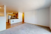 Located at 1602 E Marine View Drive in Everett, WA, this three-bedroom, two-bathroom residence offers a well-organized single-floor layout designed for comfortable everyday living. The open-concept living, dining, and kitchen area serves as the heart of the home, featuring warm wood-tone laminate flooring, recessed lighting, and a seamless flow between spaces. The kitchen is outfitted with stainless steel appliances, modern flat-front cabinetry in a wood-grain finish, dark countertops, and a peninsula with a built-in sink — ideal for both meal preparation and casual dining. The living area is carpeted and leads directly to a private balcony through sliding glass doors, allowing for natural light and outdoor access. Three carpeted bedrooms provide comfortable retreats, each with generous wall space and closet access. The primary bedroom is served by a walk-in closet with wire shelving on multiple walls. Two full bathrooms are present, including one with a full tub-and-shower surround and hardwood-style flooring. A dedicated laundry area and a central hallway connecting the bedrooms add to the unit's functional design. With four closets throughout, storage is a notable feature of this well-appointed residence.