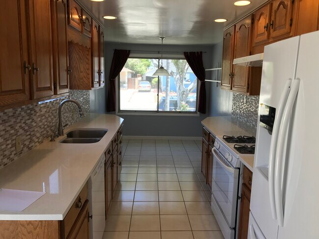 Cocina con luminoso rincón para desayunar, iluminación empotrada, encimeras de cuarzo nuevas y horno, lavavajillas. - 14911 Fonthill Ave
