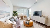 Located in Rancho Cucamonga, CA, this well-appointed one-bedroom, one-bathroom residence offers a comfortable and thoughtfully designed single-floor layout. The open-concept living room and kitchen area serves as the heart of the home, bathed in natural light from large windows and a glass door that opens directly onto a private balcony with outdoor views. The living area features warm wood-style flooring, recessed lighting, and a bright, neutral color palette that creates an inviting ambiance. The kitchen is outfitted with crisp white cabinetry, dark countertops, open shelving, and a full suite of stainless steel appliances including a gas range, microwave, dishwasher, and refrigerator. The bedroom is a serene retreat with plush carpeting, a ceiling fan, a generous window that allows natural light to filter in, and ample space for furnishings. The bathroom offers a clean, modern aesthetic with white vanity cabinetry, dark countertops, a large mirror, and wood-look flooring. A hallway connects the rooms efficiently, completing this well-organized and comfortable floor plan ideal for those seeking a move-in ready home in Southern California.