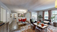 Located at 1900 Tree Mountain Parkway in Stone Mountain, Georgia, this well-designed 2-bedroom, 3-bathroom home offers a thoughtfully organized single-floor layout. The open-concept living and dining areas are anchored by rich hardwood-style flooring, with the living room offering generous space for seating and natural light streaming in through large windows with decorative draping. A separate dining area accommodates a full dining set beneath a pendant light fixture, with direct access to an outdoor balcony area. A second dining space provides additional flexibility for entertaining or casual meals. The kitchen features white cabinetry, granite-style countertops, black appliances, and light wood-style flooring, complemented by a butcher block island for additional prep space. The primary bedroom is generously proportioned, with plush carpeting, large windows, and ample room for a full bedroom suite. The second bedroom, also carpeted and well-lit, offers versatility as a guest room or home office. Three full bathrooms serve the home, each finished with white vanities and granite-style countertops, with at least one featuring a full soaking tub. Two closets provide practical storage throughout. The textured ceilings and neutral gray-toned walls create a cohesive, modern ambiance throughout the entire home.