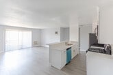 Located at 1538 N Vista St in the heart of Los Angeles, this single-floor unit offers a clean, modern aesthetic with an open-concept design that seamlessly connects the kitchen and living areas. Wood-style plank flooring runs throughout, providing a warm and cohesive foundation across the space.

The kitchen is a standout feature, outfitted with white shaker cabinetry, quartz countertops, a mosaic tile backsplash, and a full suite of stainless steel appliances including a gas range, over-the-range microwave, refrigerator, and dishwasher. A peninsula with bar seating extends into the main living area, making it ideal for both meal preparation and casual dining.

The open living area is generously sized, bathed in natural light from a large sliding glass door fitted with vertical blinds. A wall-mounted AC unit provides climate control, and the neutral gray wall palette creates a bright, airy atmosphere throughout.

A separate bedroom offers a quiet retreat, featuring the same wood-style flooring and a soft, muted wall color that complements the overall design language of the unit. Recessed lighting and flush-mount fixtures provide consistent illumination, while clean white baseboards and trim add a polished finishing touch to every room.
