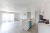 Located at 1538 N Vista St in the heart of Los Angeles, this single-floor unit offers a clean, modern aesthetic with an open-concept design that seamlessly connects the kitchen and living areas. Wood-style plank flooring runs throughout, providing a warm and cohesive foundation across the space.

The kitchen is a standout feature, outfitted with white shaker cabinetry, quartz countertops, a mosaic tile backsplash, and a full suite of stainless steel appliances including a gas range, over-the-range microwave, refrigerator, and dishwasher. A peninsula with bar seating extends into the main living area, making it ideal for both meal preparation and casual dining.

The open living area is generously sized, bathed in natural light from a large sliding glass door fitted with vertical blinds. A wall-mounted AC unit provides climate control, and the neutral gray wall palette creates a bright, airy atmosphere throughout.

A separate bedroom offers a quiet retreat, featuring the same wood-style flooring and a soft, muted wall color that complements the overall design language of the unit. Recessed lighting and flush-mount fixtures provide consistent illumination, while clean white baseboards and trim add a polished finishing touch to every room.