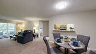 Located in Eden Prairie, MN, this single-floor, three-bedroom, two-bathroom residence offers a practical and comfortable layout. The open-plan living and dining area is carpeted throughout, providing a warm and cohesive feel. The living room features a sliding glass door that opens to a balcony with lush outdoor views, filling the space with natural light. A wall-mounted AC unit ensures year-round comfort. The kitchen is equipped with light wood cabinetry, stainless steel appliances including a refrigerator, range, and microwave, and connects seamlessly to the dining area via a pass-through counter. The primary bedroom is generously sized with a ceiling fan, a window overlooking greenery, and ample floor space. The two additional bedrooms also feature ceiling fans, carpeted floors, and windows with outdoor views. A carpeted hallway lined with built-in closets leads to the full bathroom, which includes a tub-shower combination and tile flooring. The second bathroom features warm-toned tile flooring, a wood-cabinet vanity, and a tub-shower combination. A dedicated laundry area adds everyday convenience. Neutral wall tones and clean finishes throughout contribute to a bright, move-in-ready atmosphere.