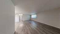 Located at 4010 North Brandywine Drive in Peoria, Illinois, this well-laid-out 2-bedroom, 2-bathroom unit offers a comfortable and functional single-floor living experience. The spacious living area is finished with durable hardwood-style flooring and neutral gray walls, creating a clean, versatile backdrop. A large window dressed with vertical blinds fills the room with natural light, while a textured ceiling adds subtle character throughout. The layout flows naturally into a dining area accented by a chandelier, connecting to the galley-style kitchen. The kitchen features light wood cabinetry, granite-look countertops, a stainless steel sink, and black appliances including a refrigerator, range, and dishwasher, all set on light wood-style flooring. Both bedrooms are carpeted for comfort and include windows with vertical blinds that bring in natural light. The primary bedroom offers generous proportions with ample room to furnish. The second bedroom also features hardwood-style flooring. Each bathroom is well-appointed with wood-tone vanities, white countertops, and modern lighting. Two closets provide practical storage throughout the unit. Overall, this residence presents a clean, move-in-ready space with a neutral palette suited for a variety of personal styles.