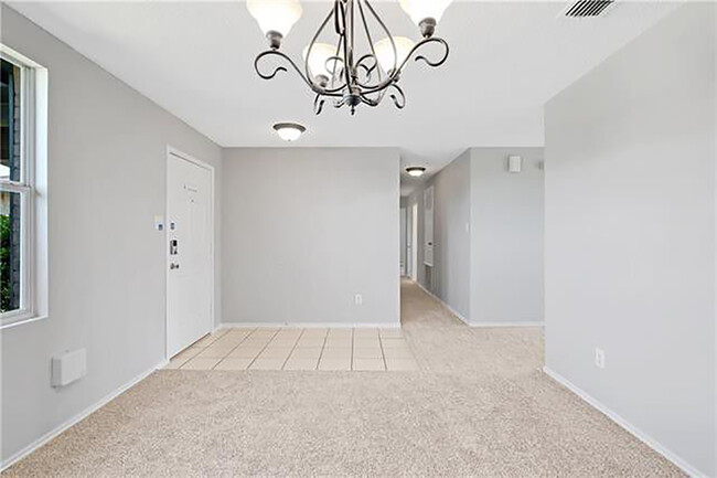 Front entry looking down hallway to secondary bed/bathrooms. Woodgrain tile at entry not pictured. - 1419 Windy Meadows Dr