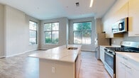 Located at 850 Pacific Street in Stamford, CT, this well-appointed 2-bedroom, 2-bathroom residence offers a thoughtfully designed single-floor layout with generous living space. The open-concept kitchen and living area serves as the heart of the home, highlighted by a large center island with striking quartz countertops and an integrated sink. Light wood cabinetry, stainless steel appliances — including a gas range, microwave, and refrigerator — and abundant natural light streaming through oversized windows complete the kitchen. The living area benefits from tall ceilings and views of the surrounding greenery. Wood-style flooring flows consistently throughout the entire residence, adding warmth and cohesion to every room. The spacious primary bedroom features large windows that invite natural light and outdoor views, along with access to ample closet space fitted with wire shelving systems. The second bedroom is equally bright, with its own window framing neighborhood views. Both bathrooms are clean and modern, featuring white vanities and full tub-shower combinations. Additional conveniences include a dedicated pantry, in-unit laundry, a hallway with a utility panel, and four closets providing exceptional storage throughout the home.