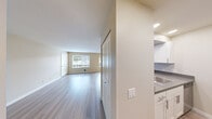 Located at 3030 NE 143rd St. in Seattle, WA, this two-bedroom, one-bathroom unit offers a well-organized, single-floor layout designed for comfortable everyday living. The entrance opens to a bright, open living area featuring light wood-style flooring and neutral warm-toned walls that create a clean, welcoming atmosphere. Large windows allow natural light to flow throughout, providing views of the surrounding neighborhood.

The galley-style kitchen is efficiently designed with white shaker cabinetry, gray countertops, a stainless steel sink, a dishwasher, and an electric range, maximizing both storage and workspace within a compact footprint.

The generously sized primary bedroom is carpeted and features sliding glass doors that open directly onto a private balcony, offering outdoor access and additional natural light. The second bedroom also features light wood-style flooring and connects conveniently to the shared bathroom area.

The bathroom includes a wide vanity with white cabinetry, gray countertops, an oversized mirror, and well-placed overhead lighting. A dedicated walk-in closet with built-in shelving provides ample storage. Throughout the unit, the neutral color palette, clean finishes, and thoughtful layout come together to create a practical and comfortable living space.