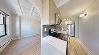 Located at 1211 North La Salle Drive in Chicago's prestigious Gold Coast neighborhood, this one-bedroom, one-bathroom unit blends classic architectural character with modern updates. Throughout the home, light hardwood floors and striking coffered ceilings create a bright, refined aesthetic that ties each room together seamlessly.

The combined living and dining area is generously proportioned, featuring large windows with views of the surrounding cityscape, allowing abundant natural light to fill the space. An elegant arched passageway connects the living area to the kitchen, adding a timeless architectural detail. The kitchen has been thoughtfully updated with light wood cabinetry, white countertops, a tiled backsplash, and stainless steel appliances including a refrigerator, electric range, microwave, and dishwasher.

The bedroom offers a comfortable footprint with its own coffered ceiling, a window for natural light, and a double-door closet for storage. An additional closet provides further storage convenience. The bathroom is finished with floor-to-ceiling marble-style tile surrounding the soaking tub, complemented by a wood-toned vanity and clean white countertop. Wall sconces and track lighting add warmth throughout, completing this well-appointed Gold Coast residence.