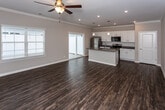 Located at 2209 Ashford Villa Circle in Chattanooga, TN, this single-floor home offers a well-designed, open-concept layout that seamlessly connects the living and kitchen areas. Rich, dark hardwood-style flooring flows throughout the space, complemented by neutral-toned walls and crisp white trim that create a clean, cohesive aesthetic.

The kitchen is a standout feature, showcasing white shaker-style cabinetry, granite countertops with subtle veining, a white subway tile backsplash, and a full suite of stainless steel appliances including a refrigerator, range, and microwave. A center island with an integrated sink and pendant lighting above adds both function and style, while a sliding glass door brings in abundant natural light and provides outdoor access.

The living area is generously proportioned, featuring crown molding, recessed lighting, and a ceiling fan — creating a comfortable, airy atmosphere. Bedrooms continue the hardwood-style flooring and include ceiling fans and open closets with built-in shelving for practical storage.

The bathroom is well-appointed with white cabinetry, granite countertops, a single undermount sink, a large mirror, and a tub/shower combination. A window allows natural light to brighten the space. Hallways feature additional closet storage, rounding out this thoughtfully laid-out home.