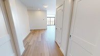 This contemporary apartment, located at 2016 Linkway Blvd in London, Ontario, offers 940 square feet of thoughtfully designed living space. The floor plan encompasses three bedrooms, including a spacious 160 square foot primary bedroom, and two well-appointed bathrooms. The heart of the home is an open-concept kitchen and living area, showcasing a sleek design with white cabinetry, stainless steel appliances, and a large kitchen island finished in a soft blue hue. The living spaces are bathed in natural light, courtesy of floor-to-ceiling windows that offer stunning cityscape views. A standout feature is the balcony, accessible through sliding glass doors, providing an outdoor extension of the living area. Throughout the apartment, warm-toned hardwood flooring creates a cohesive and inviting atmosphere. The bathrooms are elegantly finished, with one featuring a luxurious walk-in shower with marble-like tiling. This single-floor residence combines modern aesthetics with functional design, making efficient use of its compact footprint while maintaining a sense of spaciousness and urban sophistication.