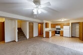 Located at 5007 Panorama Ln in Columbia, Missouri, this two-story home offers a practical and comfortable layout across two well-proportioned floors. The main level features an open-concept living and kitchen area, where warm honey-toned cabinetry, tile flooring, and white appliances — including a dishwasher, electric range, microwave, and refrigerator — come together in a functional kitchen design. A dedicated pantry closet provides added storage. The living area transitions seamlessly from tile to carpet, is brightened by natural light from sliding glass doors and windows overlooking the greenery outside, and is finished with a ceiling fan overhead. A dedicated laundry area with washer and dryer hookups is conveniently located on the main floor. The attached garage offers generous vehicle and storage space with an automatic opener. Upstairs, three carpeted bedrooms each feature ceiling fans, with the primary bedroom offering a comfortable footprint. Four closets throughout — including a spacious walk-in with wire shelving — provide ample storage. Three full bathrooms include clean, classic vanities with wood cabinetry and large mirrors. The home presents a straightforward, well-maintained interior suited for everyday living in a residential Columbia neighborhood.