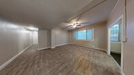 Located at 306 Blanchard St in Seattle's Belltown neighborhood, this 2-bedroom, 1-bathroom residence offers a well-organized, single-floor layout across a comfortable footprint. The living room is generously proportioned, featuring plush wall-to-wall carpeting, a ceiling fan, a textured ceiling, and a large window that brings in natural light. Baseboard heating is found throughout the home, ensuring consistent warmth. The kitchen has been updated with crisp white shaker-style cabinetry reaching to the ceiling, marble-patterned countertops, a tile floor, and a full suite of white appliances including a refrigerator, dishwasher, and range. Both bedrooms are carpeted and equipped with windows and baseboard heaters; the primary bedroom is notably spacious and includes a ceiling fan. The second bedroom offers a cozy, well-lit space with a window featuring blinds. A carpeted hallway connects the rooms and includes three closets for ample storage. The bathroom is clean and functional, featuring a tiled floor, a full bathtub and shower combination, and simple white finishes. The layout flows efficiently, making practical use of every area throughout the home.