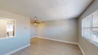 This single-story unit in Milton, Florida offers a practical and well-appointed layout across two bedrooms and one bathroom. The living area serves as the central gathering space, finished with light wood-look flooring, soft gray walls, white baseboards, a textured ceiling, and a ceiling fan with integrated lighting. A pass-through window connects the living area to the kitchen, providing an open, communicative feel between the two spaces.

The kitchen is equipped with white shaker-style cabinetry, granite-look countertops, a stainless steel range with an overhead exhaust hood, a stainless steel sink, and a gray subway tile backsplash—offering a clean, modern aesthetic in a compact footprint.

Both bedrooms continue the consistent flooring and neutral wall tones seen throughout the unit. Each room features a window fitted with blinds, allowing natural light while maintaining privacy. The textured ceilings and ceiling-mounted HVAC vents carry through to these rooms as well.

The bathroom is straightforward and functional, featuring a tub-shower combination with a curved curtain rod, a vanity with storage, and the same light wood-look flooring found in the rest of the unit. The overall ambiance of the space is clean, bright, and move-in ready.