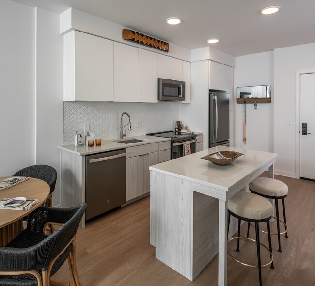 White flat front cabinetry and an open concept kitchen - The Lucie