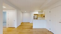 Located at 11603 NE 71st St in Vancouver, WA, this well-designed two-bedroom, two-bathroom unit offers a clean, modern aesthetic throughout its single-floor layout. Light hardwood flooring flows through the open-concept living and kitchen area, creating a bright and cohesive feel. The kitchen is a standout feature, equipped with stainless steel appliances including a refrigerator, gas range, and built-in microwave, complemented by light wood cabinetry, white quartz countertops, and a peninsula that separates it from the living area — ideal for casual dining or entertaining. The living room is airy and open, connecting seamlessly to the kitchen and hallways. The primary bedroom is generously sized, featuring direct outdoor access through a glass door, a wall-mounted HVAC unit, and a bright window with outdoor views. The second bedroom is finished with plush carpet, dual windows for natural light, and a built-in closet. Both bathrooms are clean and functional, each featuring a full tub and shower combo, wood-toned vanity, and light hardwood flooring. Hallways connect the rooms efficiently, and the overall palette of whites and natural wood tones lends the space a fresh, contemporary character throughout.