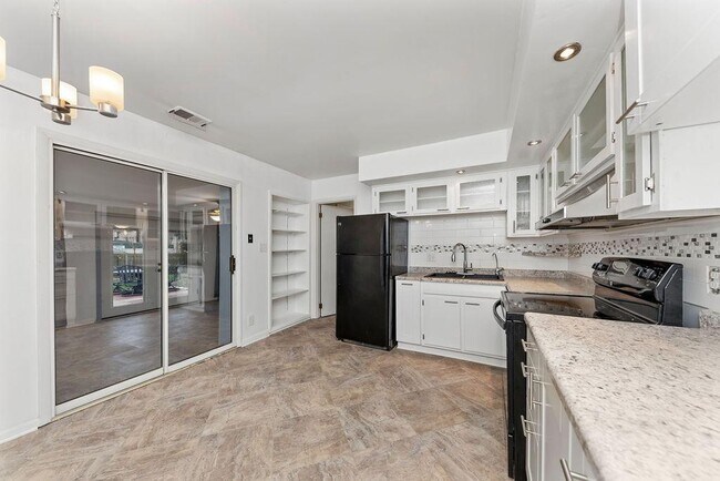 ¡Preciosa cocina reformada con armarios con puertas de cristal y muchísimo espacio de almacenamiento! Todos los electrodomésticos incluidos: cocina, frigorífico y lavavajillas. La cocina se abre a una terraza acristalada, un encantador patio y un jardín trasero completamente vallado. - 11 Lawndale Ave