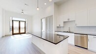 Located at 10221 Whistle Stop Lane in Frisco, TX, this well-appointed 2-bedroom, 2-bathroom residence offers a thoughtfully designed single-floor layout. The open-concept living, dining, and kitchen area serves as the heart of the home, anchored by a striking kitchen island with dark granite countertops and a built-in wine rack. White shaker cabinetry, a subway tile backsplash, stainless steel appliances, and pendant lighting complete the modern kitchen, which also features a dedicated pantry. Light hardwood flooring flows throughout the main living areas, while a ceiling fan and access to a private balcony enhance the bright, airy atmosphere with sweeping outdoor views. The generously sized primary bedroom is bathed in natural light and connects to a walk-in closet and a well-appointed en-suite bathroom featuring dark granite countertops, a dual vanity with illuminated mirrors, and a tiled soaking tub. The second bedroom offers plush carpet flooring and ample natural light. A dedicated laundry room with a full-size washer and dryer adds everyday convenience. High ceilings throughout the home amplify the sense of openness, creating a refined and functional living environment.