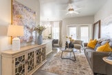 Located at 141 Nopan Rd in El Paso, Texas, this single-story residence presents a thoughtfully designed interior with modern finishes and a cohesive neutral color palette. Wood-look flooring runs throughout the home, providing a warm, unified aesthetic that connects each space seamlessly.

The living area serves as the heart of the home, featuring a ceiling fan, textured ceiling, and an abundance of natural light streaming through French doors fitted with white plantation shutters. The open layout allows for comfortable furnishing arrangements, while the connection to adjacent spaces enhances the overall flow.

The kitchen is well-appointed with white shaker-style cabinetry, granite-look countertops, and a full suite of stainless steel appliances, including a range, microwave, refrigerator, and dishwasher. Recessed lighting and ample counter space make this a highly functional area.

The bedroom is a calm retreat with large windows dressed in elegant draping curtains and plantation shutters, allowing for controlled natural light. A ceiling fan adds comfort overhead.

The bathroom features a full tub-shower combination with wood-look tile surround, white cabinetry with granite countertops, and warm vanity lighting, creating a clean and polished finish. Together, these spaces offer a comfortable and stylish living environment.