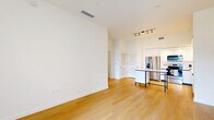 Located in Miami Lakes, this thoughtfully designed two-bedroom, one-bathroom residence offers a clean, modern aesthetic throughout. Light wood flooring runs continuously across the entire unit, creating a warm and cohesive feel from room to room. The open-concept living and kitchen area serves as the heart of the home, where the sleek kitchen stands out with white flat-panel cabinetry extending to the ceiling, stainless steel appliances including a refrigerator with ice maker, electric range, microwave, and dishwasher, all complemented by a white countertop and classic subway tile backsplash. A kitchen island with a contrasting dark frame adds a modern design touch. Track lighting illuminates the space effectively. The living area flows naturally from the kitchen, offering a bright, open environment. Both bedrooms are well-proportioned and finished in crisp white tones. The primary bedroom features direct access to a private outdoor balcony with views of surrounding greenery and a ceiling fan for added comfort. The second bedroom benefits from a large window framing tropical outdoor views. A spacious walk-in closet with built-in wire shelving provides generous storage. The bathroom is finished with a white vanity, large-format tiled walk-in shower with sliding glass doors, and wood-tone flooring, maintaining the unit's clean, contemporary style throughout.