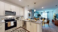 Located at 1630 Peachtree Industrial Blvd in Suwanee, GA, this 2-bedroom, 2-bathroom residence offers a thoughtfully designed single-floor layout that balances modern aesthetics with everyday functionality. The open-concept kitchen is a standout feature, showcasing light wood cabinetry, granite countertops, a classic subway tile backsplash, and a full suite of stainless steel appliances including a French door refrigerator, electric range, built-in microwave, and dishwasher. A peninsula with a double sink and pendant lighting connects the kitchen seamlessly to the dining and living areas. The living room is bright and inviting, featuring large windows that allow abundant natural light, a ceiling fan, and a bold teal accent wall that adds a contemporary flair. Both bedrooms are generously sized with plush carpeting and bold accent walls that lend each room its own character. One bedroom features a walk-in closet, while both rooms offer ample storage. The bathrooms are cleanly finished with granite-topped vanities, light wood cabinetry, and a tub-shower combination with white tile surrounds. Wood-look flooring runs throughout the main living areas, tying together a cohesive and modern interior design throughout.