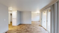 Located at 3684 Fisher Rd NE in Salem, Oregon, this single-floor 2-bedroom, 1-bathroom residence offers a practical and well-organized layout. The open living room is bright and welcoming, featuring light wood-look flooring, neutral walls, a classic chandelier, and a sliding glass door that fills the space with natural light and provides access to an outdoor area. The galley-style kitchen runs efficiently along two walls and is equipped with white cabinetry featuring wood-tone trim, laminate countertops, a white appliance suite including a range, dishwasher, and refrigerator, and ample overhead storage. Both bedrooms are carpeted and receive natural light through large windows with views of the surrounding neighborhood. The primary bedroom offers a comfortable footprint, while the second bedroom provides additional flexibility. A dedicated laundry room includes washer and dryer hookups with overhead wire shelving for added storage convenience. The full bathroom features wood-look flooring, a tub-shower combination, a vanity with countertop space, and a large mirror. Clean finishes and a neutral color palette throughout create a cohesive and move-in-ready atmosphere.