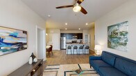 This 1-bedroom, 1-bathroom unit is thoughtfully designed with an open-concept layout that seamlessly connects the living, dining, and kitchen areas. Wood-style plank flooring flows throughout, complemented by neutral wall tones and recessed lighting that create a warm, inviting atmosphere.

The kitchen is a standout feature, showcasing dark espresso cabinetry, granite countertops, a white subway tile backsplash, and a full suite of stainless steel appliances including a refrigerator, range, and built-in microwave. A peninsula with bar seating provides additional prep space and casual dining options, while a dedicated pantry offers generous storage.

The dining area is positioned adjacent to the kitchen and is illuminated by a modern pendant light, making it an ideal spot for everyday meals. The living room is bright and airy, featuring a ceiling fan, large French doors that invite natural light, and ample space for comfortable furnishings.

The bedroom is a serene retreat with a ceiling fan, windows with natural light, and wood-style flooring. The full bathroom is spacious and includes a tub-shower combination and hardwood-style flooring. An in-unit laundry area adds everyday convenience, rounding out this well-equipped and functional home.