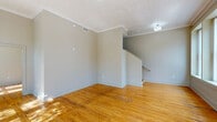 Located at 1601 Main St in the heart of Columbia, SC, this one-bedroom, one-bathroom residence offers a well-designed layout across a single floor. The living area is immediately welcoming, featuring warm, honey-toned hardwood floors that run throughout and a textured ceiling that adds character to the space. A staircase is prominently positioned in the main living area, serving as a functional architectural element. Large, tall windows flood the living room with generous natural light, framing views of the tree-lined streetscape outside.

The hallway connects the living spaces to the private areas of the home, leading to the bedroom, which benefits from its own oversized window with street-facing views, continuing the natural light theme. A dedicated walk-in closet accompanies the bedroom, outfitted with wire shelving and hanging rods to maximize storage. The bathroom is clean and modern, featuring large-format gray tile flooring, a dark espresso vanity with a granite-topped sink, a well-lit mirror, and a bathtub/shower combination. Neutral wall tones throughout the residence create a cohesive and versatile backdrop suited to a variety of interior styles.