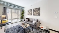 Located at 412 12th Ave SE in Minneapolis, MN, this 2-bedroom, 1-bathroom unit offers a well-designed layout across a single floor. The open-concept kitchen and living area serves as the heart of the home, where a modern kitchen features white cabinetry, subway tile backsplash, stainless steel appliances, and a peninsula with bar seating illuminated by sleek pendant lighting. The kitchen flows seamlessly into the living area, which is anchored by large floor-to-ceiling windows that flood the space with natural light and provide views of the outdoors. Light wood-tone flooring runs throughout, enhancing the bright and airy atmosphere. Exposed ductwork along the ceiling adds an urban, industrial character to the space. Both bedrooms are comfortably sized, with the primary bedroom offering generous closet space, a ceiling fan, and a window. The full bathroom is clean and functional, featuring a walk-in shower with a sliding glass door, white cabinetry with a gray quartz countertop, and open shelving. Additional highlights include four closets for ample storage and a dedicated in-unit laundry area, making this a practical and stylish home in the heart of Minneapolis.