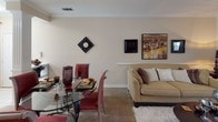 Located at 700 Greenlawn Dr in Columbia, South Carolina, this single-floor residence offers a thoughtfully designed layout that balances comfort and functionality. The living room features crown molding, a wainscoting-style chair rail, neutral carpet, and a warm, inviting ambiance accentuated by soft lighting and tasteful décor. Adjacent to the living area, the dining space accommodates a glass-top dining table and flows naturally into the common areas, creating an open, connected feel.

The kitchen is equipped with warm wood cabinetry offering generous storage, white countertops, and standard appliances including an electric range with oven, providing a practical and efficient cooking environment with wood-look flooring underfoot.

The residence includes multiple bedrooms, each finished with plush carpeting, large windows that bring in natural light, and sliding mirrored closet doors offering ample storage. The primary bedroom is generously proportioned and features a walk-in-style closet.

Both bathrooms are finished with wood-look flooring, warm-toned walls, and oak cabinetry with white countertops. One bathroom features a shower/tub combination, while the other offers a more compact layout with a vanity and toilet. Together, these spaces reflect a cohesive, comfortable residential design throughout.