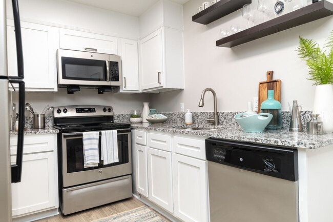 Kitchen with granite counters, stainless appliances, and modern cabinetry - Eastwood Greene