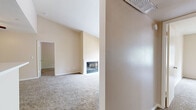 This single-story, 3-bedroom, 2-bathroom home in San Ramon, CA offers a well-designed layout with comfortable living spaces throughout. The living room is a standout area, featuring vaulted ceilings that enhance the sense of openness, plush carpeting, and a classic fireplace framed by a clean white surround. Sliding glass doors lead to a private balcony, flooding the room with natural light and offering peaceful views of surrounding greenery. The kitchen is thoughtfully designed with rich dark cabinetry, white countertops, stainless steel appliances including a refrigerator, microwave, and electric range, and durable hardwood-style flooring. A peninsula counter connects the kitchen to the living area, creating an open and functional flow. A ceiling fan is installed in the main living zone for added comfort. Each of the three bedrooms is carpeted and features neutral warm-toned walls. The primary bedroom is generously sized and includes a walk-in closet with built-in shelving. The secondary bedrooms offer ample space and natural light through large windows. Both bathrooms are finished with dark wood vanities, white countertops, hardwood-style flooring, and full shower-tub combinations with brushed nickel fixtures. A hallway connects the bedrooms and bathrooms, completing this efficiently organized home.