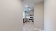 This single-floor, 2-bedroom, 2-bathroom residence in Lady Lake, Florida offers a thoughtfully designed layout with modern finishes throughout. The open-concept kitchen serves as the heart of the home, featuring granite countertops, gray shaker-style cabinetry, a subway tile backsplash, stainless steel appliances, and a peninsula with pendant lighting — all flowing seamlessly into the living area over light wood-look flooring. Natural light pours in through multiple windows, enhancing the bright, airy atmosphere.

Both bedrooms are carpeted for comfort, each equipped with a ceiling fan and windows with blinds that invite natural light. The primary bedroom is generously proportioned and connects to a private en-suite bathroom boasting a dual-sink vanity with granite countertops, gray cabinetry, and a tiled shower. The second full bathroom mirrors the same refined aesthetic, offering a granite-topped single vanity and a tiled tub-shower combination. Additional conveniences include two closets, a hallway, and a welcoming entrance. The neutral color palette and clean architectural lines throughout create a cohesive, modern living environment.