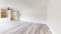 Located at 14500 Olive View Dr in the Sylmar neighborhood of Los Angeles, this single-floor, 2-bedroom, 1-bathroom unit offers a functional and well-appointed layout. The living room is a spacious, light-filled area featuring wood-look laminate flooring, neutral-toned walls, a textured ceiling, and a wall-mounted air conditioning unit. A sliding glass door opens to a private balcony, allowing natural light to pour into the space. The kitchen is efficiently designed with gray cabinetry, a subway tile backsplash, a gas range, stainless steel appliances, and a white marble-style breakfast bar that separates it from the living area. Both bedrooms feature plush carpeting and neutral walls. The primary bedroom is a generously sized room with a large sliding-door closet, while the second bedroom includes built-in shelving and a window with vertical blinds. A hallway connects the bedrooms to the shared bathroom, which is outfitted with a wide vanity featuring a white countertop, under-sink storage with black hardware, and a shower-tub combination. The consistent use of light tones and clean finishes throughout gives the unit a cohesive, move-in-ready feel.