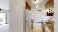 Located at 1631 Carl St in Lauderdale, MN, this 2-bedroom, 1-bathroom unit offers a practical and well-organized single-floor layout. The galley-style kitchen features rich, dark wood cabinetry, granite-look countertops, a stainless steel sink, and white appliances including a range and refrigerator. Light tile flooring runs through the kitchen, which connects seamlessly to a hallway leading to the rest of the unit. Both bedrooms are carpeted and finished with warm wood baseboards, offering a comfortable feel. The spacious primary bedroom includes a ceiling fan with light fixture and a window with blinds that allow natural light to filter in, along with baseboard heating. The second bedroom also features carpet, a ceiling fan, and a closet with sliding panel doors. The full bathroom is tiled and includes a pedestal sink, medicine cabinet with overhead lighting, a soaking tub with shower, and overhead storage cabinetry. Throughout the unit, wood-trimmed doors and consistent neutral wall tones create a cohesive, understated aesthetic. The overall layout is efficient and functional, making smart use of the available space across each room.