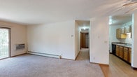 This single-floor unit offers a clean, functional layout designed for comfortable everyday living. The spacious living room features wall-to-wall carpeting, a ceiling fan, and a sliding glass door that opens to a private balcony overlooking lush greenery, filling the space with natural light. Baseboard heating is present throughout, ensuring warmth across all rooms.

The galley-style kitchen is efficiently arranged with warm oak cabinetry, laminate countertops, a stainless steel double sink, and a full suite of appliances including a refrigerator, electric range, microwave, and dishwasher. Light wood-style flooring runs underfoot, adding a clean, practical finish.

The unit includes multiple bedrooms, each carpeted and featuring windows with outdoor views and baseboard heating, creating comfortable, naturally lit retreats. Ample closet storage is also available.

Two bathrooms serve the unit. The full bathroom includes a tiled tub-shower combination, a wood-vanity with a granite-style countertop, and tile flooring. A second bathroom offers a similarly styled vanity with additional counter space.

Overall, the unit presents a straightforward, well-maintained interior with neutral tones, practical finishes, and a functional flow throughout.