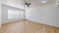 Located at 8050 Gables Commons Dr in Orlando, FL, this single-story residence offers four bedrooms and six bathrooms across a well-designed floor plan. Light wood-tone flooring flows consistently throughout the home, creating a clean, cohesive aesthetic. The combined living and dining area is bright and open, featuring crown molding, a ceiling fan, and large windows with blinds that allow ample natural light to fill the space. A glass door provides access to a private patio. The kitchen is a standout feature, showcasing stone countertops, a peninsula with a double undermount sink and matte black faucet, white cabinetry, a subway tile backsplash, and stainless steel appliances. A pantry adds convenient storage. The bedrooms are well-proportioned, with multiple windows offering garden views and generous closet space, including walk-in closets with built-in wire shelving. Six bathrooms serve the household, fitted with marble-style countertops, white cabinetry, and modern matte black hardware. A dedicated laundry room and multiple hallways enhance functionality. The home's clean white walls, consistent finishes, and thoughtful layout make it a comfortable and practical residence in the Orlando area.