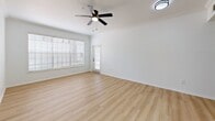 Located at 8050 Gables Commons Dr in Orlando, FL, this single-story residence offers four bedrooms and six bathrooms across a well-designed floor plan. Light wood-tone flooring flows consistently throughout the home, creating a clean, cohesive aesthetic. The combined living and dining area is bright and open, featuring crown molding, a ceiling fan, and large windows with blinds that allow ample natural light to fill the space. A glass door provides access to a private patio. The kitchen is a standout feature, showcasing stone countertops, a peninsula with a double undermount sink and matte black faucet, white cabinetry, a subway tile backsplash, and stainless steel appliances. A pantry adds convenient storage. The bedrooms are well-proportioned, with multiple windows offering garden views and generous closet space, including walk-in closets with built-in wire shelving. Six bathrooms serve the household, fitted with marble-style countertops, white cabinetry, and modern matte black hardware. A dedicated laundry room and multiple hallways enhance functionality. The home's clean white walls, consistent finishes, and thoughtful layout make it a comfortable and practical residence in the Orlando area.