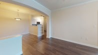 Located at 6450 Mercantile Dr E in Frederick, Maryland, this single-floor residence offers a well-designed layout with a variety of thoughtful finishes throughout. The entryway opens into a spacious living area featuring rich, dark hardwood flooring and crown molding, creating a polished and welcoming atmosphere. An elegant arched opening connects the living space to the kitchen, which is outfitted with white shaker-style cabinetry, light stone countertops, a subway tile backsplash, and a full suite of stainless steel appliances including a range, over-the-range microwave, dishwasher, and refrigerator. A convenient breakfast bar with built-in shelving adds both function and character to the kitchen area. The bedrooms are carpeted for comfort and benefit from generous natural light provided by multiple windows with white blinds. Each bedroom includes a ceiling fixture and ample closet access. The bathroom features wood-look flooring, a combined tub and shower with tile surround, a white vanity with stone countertop, and clean, neutral finishes throughout. The overall ambiance of the space is bright, clean, and move-in ready, with consistent neutral tones that complement a variety of décor styles.