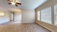 Located at 5000 Clinton Pkwy in Lawrence, Kansas, this single-story, 3-bedroom, 2-bathroom home offers a comfortable and functional layout across a generously sized floor plan. The living area features warm wood-look flooring, crown molding, a textured ceiling, and a ceiling fan, with large windows fitted with blinds that allow for abundant natural light. A pendant light fixture transitions the space seamlessly toward the kitchen. The kitchen is well-equipped with white cabinetry, light countertops, a stainless steel double-basin sink, a dishwasher, and a charming hexagonal tile backsplash, all set over wood-look flooring. The primary bedroom is a spacious retreat with plush carpeting, wide louvered closet doors, and a private ensuite bathroom featuring a tub-shower combo, white vanity cabinetry, and a linen tower for additional storage. The secondary bedrooms also feature soft carpeting and natural light. A second full bathroom mirrors the same clean, bright aesthetic with a tub-shower combo and white vanity. Three closets, including a walk-in with wire shelving, provide excellent storage. A dedicated laundry room houses a full-size washer and dryer. The home's warm neutral palette and consistent finishes create a cohesive, move-in-ready feel throughout.
