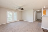 Located at 2421 Chase Park Dr in Montgomery, Alabama, this single-floor, 2-bedroom, 2-bathroom home offers a practical and comfortable layout. The galley-style kitchen is equipped with warm honey-toned wood cabinetry, white countertops, black appliances including a coil-top range and dishwasher, and a skylight that fills the space with natural light. The kitchen flows seamlessly into the living and dining area, which is illuminated by an elegant chandelier and features French doors that open to the outdoors, along with a ceiling fan overhead.

Both bedrooms are carpeted and feature ceiling fans, neutral walls, and windows that invite natural light. The spacious primary bedroom provides a comfortable retreat, while the second bedroom also offers generous proportions. Each bedroom is served by its own full bathroom, both finished with hardwood-style flooring, white vanities with granite-style countertops, and a tub/shower combination. A hallway and closet provide additional storage and connectivity throughout the home.

Textured ceilings are consistent throughout the residence, and durable hardwood-style flooring extends across the kitchen and bathroom areas, creating a cohesive aesthetic. The overall design is clean, functional, and well-suited for everyday living.
